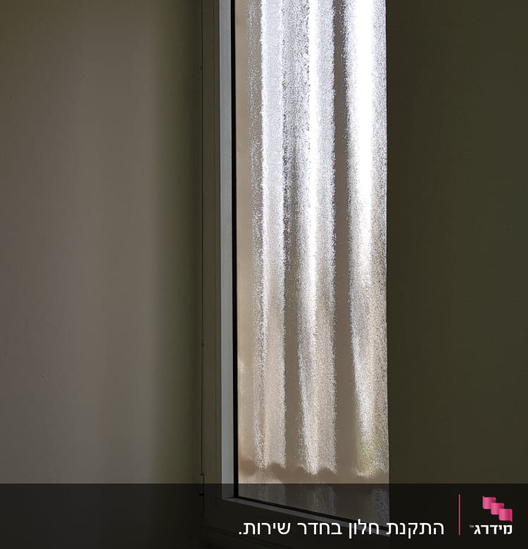 חלון עם מסגרת אלומיניום וקיר לבן
